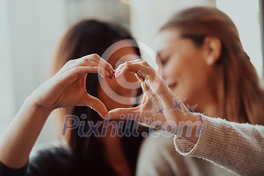 two lgbt girls romantically embracing sitting in a modern cafe two lgbt girls romantically embracing sitting in a modern cafe