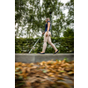 Blind woman walking on city streets, using her white cane