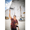 Young man flying his drone , rtaking aerial photos of a site