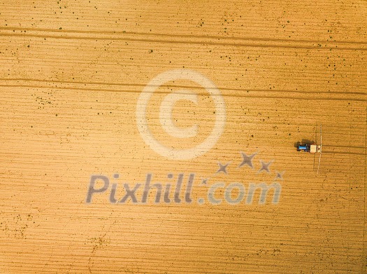 Tractor spraying crops in field, aerial view from drone pov Tractor spraying crops in field, aerial view from drone pov