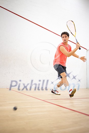Squash player in action on a squash court (motion blurred image; color toned image) Squash player in action on a squash court (motion blurred image; color toned image)