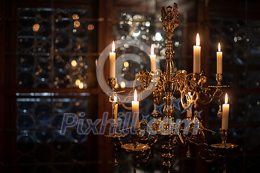 Splendid chandelier with lit candles in a beautiful room of an old mansion