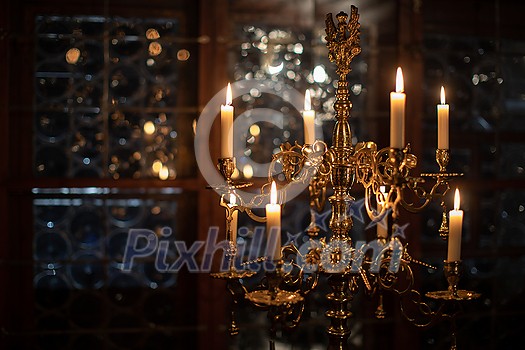 Splendid chandelier with lit candles in a beautiful room of an old mansion Splendid chandelier with lit candles in a beautiful room of an old mansion