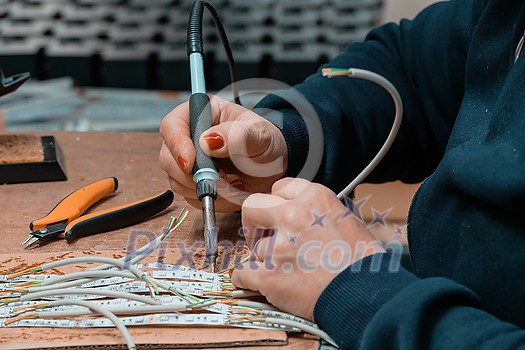 Industrial worker woman soldering cables of manufacturing equipment in a factory. High quality photo Industrial worker woman soldering cables of manufacturing equipment in a factory. High quality photo