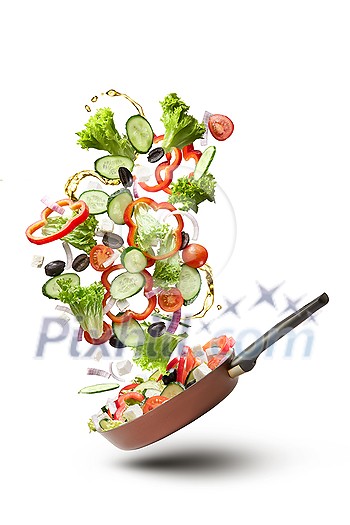 Frying pan with falling tasty fresh vegetables on white background