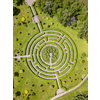 Aerial view of beautiful green natural labyrinth and trees at botanical garden in city in summer