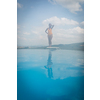 Pretty, young woman by a pool on a lovely summer day (selective focus on the water surface)