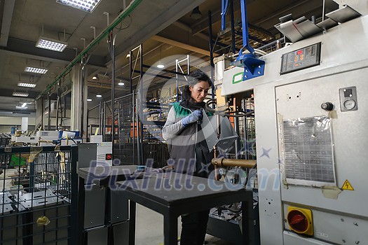 a woman working in a modern metal factory assembles parts for a new machine. High quality photo a woman working in a modern metal factory assembles parts for a new machine. High quality photo