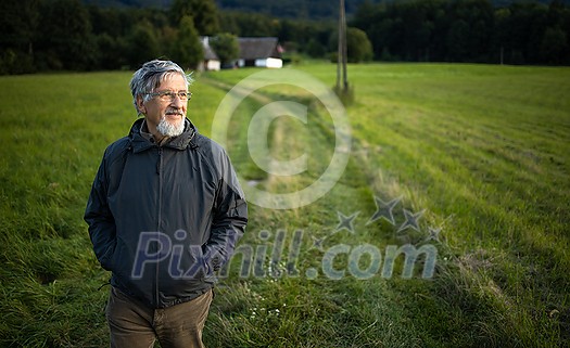 Senior man enjoying the outdoors, hiking, walking through lovely nature