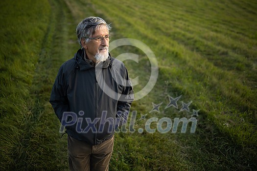 Senior man enjoying the outdoors, hiking, walking through lovely nature