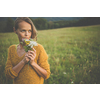 Beautiful young woman outdoors with a bouquet of wild flowers in a field, enjoying nature. Happy Woman on spring meadow