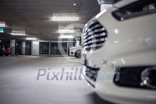 Underground parking. Cars parked in a garage with no people. Many cars in parking garage interior. Underground parking with cars (color toned image)