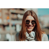 a woman in sunglasses enjoys a walk in the city while listening to music on her headphones