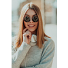 a woman in sunglasses enjoys a walk in the city while listening to music on her headphones