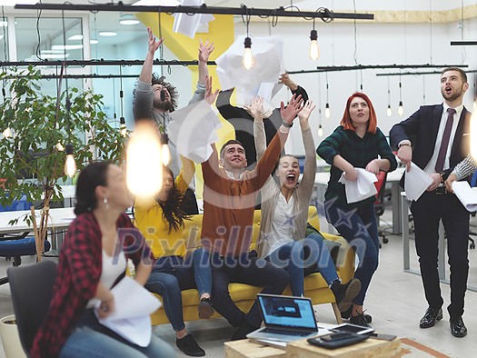 Group of business people having party and  throwing paper in air at modern coworking open space  startup office