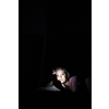 Teenage girl using her cell phone in a dark bedroom at night