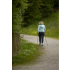 An elderly woman in nature Nordic walking outdoors. Healthy daily cardio routine.