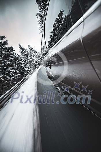 Fast moving car on a winter alpine snowy road