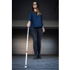 Blind woman walking on city streets, using her white cane to navigate the urban space better and to get to her destination safely