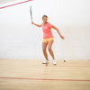 Pretty, female squash player on a squash court (motion blurred image; color toned image)