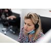 Female call center operator talking to a customer. Businesswoman in mask at the workplace in the  modern office. Social distance and safety outbreak new normal concept