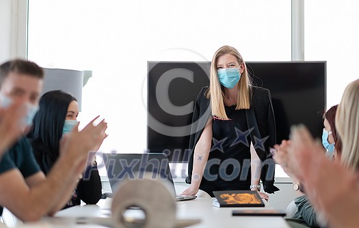 real businesspeople on business meeting in bright office on coronavirus new normal time wearing protective medical face mask and keep distance