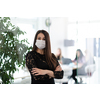 business woman portrait wearing medical mask in bright modern office new normal coronavirus outbreak concept real people