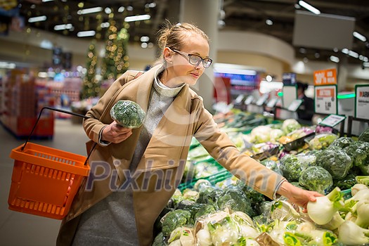 shopping, food, sale, consumerism and people concept - happy woman at grocery store or supermarket buying vegetables