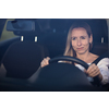 Pretty midle aged woman at the steering wheel of her car, going fast