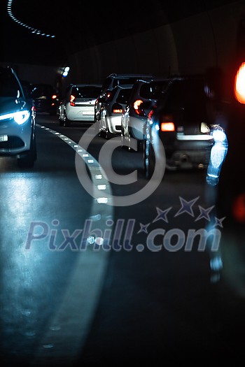 Heavy Traffic Inside A Highway Urban Tunnel. Cars going slow through a tunnel due to a congestion, traffic jam. Heavy Traffic Inside A Highway Urban Tunnel. Cars going slow through a tunnel due to a congestion, traffic jam.