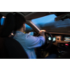 Driving a car at night - young man driving his modern car at night in a city (color toned image, motion blurred imag)