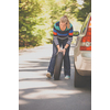 Pretty, young woman with her car broken down by the roadside, setting up the safety triangle, waiting for assistance