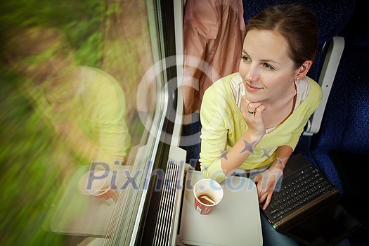 Young woman traveling by train (landscape moving fast behind the window (motion blurred image) Young woman traveling by train (landscape moving fast behind the window (motion blurred image)