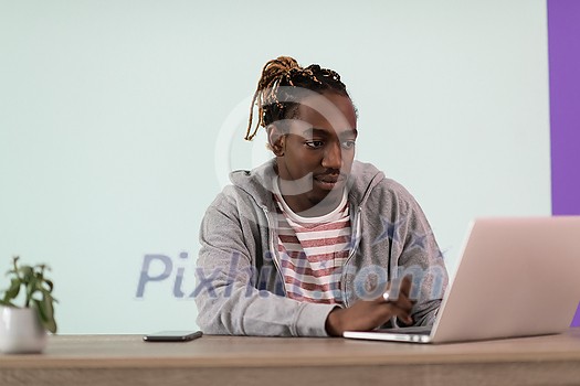 an afro young man sits in his home office during a pandemic and uses laptop for online meeting
an afro young man sits in his home office during a pandemic and uses laptop for online meeting