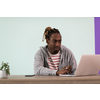 an afro young man sits in his home office during a pandemic and uses laptop for online meeting 
