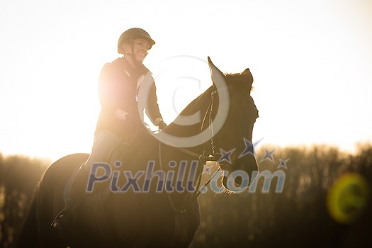 Female horse rider riding outdoors on her lovely horse Female horse rider riding outdoors on her lovely horse