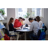 students in a modern environment work together to more easily complete a school project