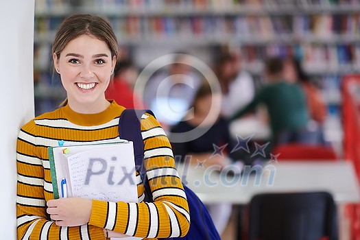 a portrait of a girl holding a notebook in her hand while standing in front of the library