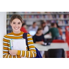 a portrait of a girl holding a notebook in her hand while standing in front of the library