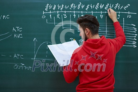 the student uses a book trying to make a math problem on the board