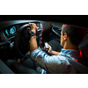 Driving a car at night - young man driving his modern car at night, in a city (shallow DOF; color toned image)