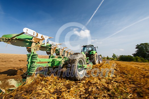 Tractor working on the farm, modern agricultural transport, farmer working in the field, tractor on a sunset background, cultivation of land, agricultural machine