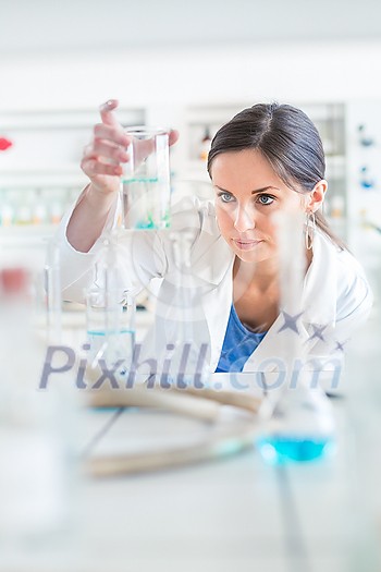 Young, female researcher carrying out experiments in a lab (shallow DOF; color toned image) Young, female researcher carrying out experiments in a lab (shallow DOF; color toned image)