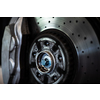 Car in a garage for maintenance, oil, tyre change (shallow DOF; color toned image) - disc brakes detail