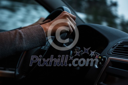 Driver's hands driving a car on a highway (color toned image; shallow DOF) Driver's hands driving a car on a highway (color toned image; shallow DOF)