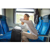 Pretty young woman aboard a train, going for her vacation destination