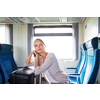 Pretty young woman aboard a train, going for her vacation destination