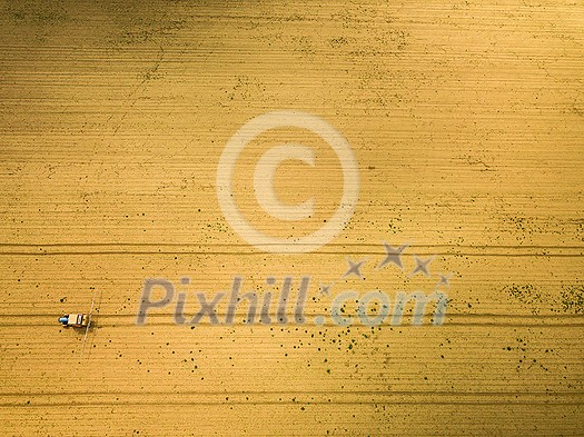 Tractor spraying crops in field, aerial view from drone pov Tractor spraying crops in field, aerial view from drone pov