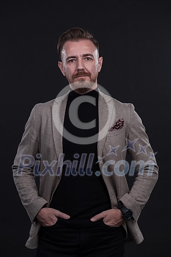 portrait of a stylish elegant businessman looking at camera in photo studio on dark background with hard light. High quality photo
