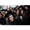 education, graduation, technology and people concept - group of happy international students in mortar boards and bachelor gowns with diplomas taking selfie by smartphone